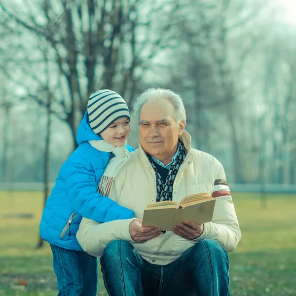 Grandfather and grandson reading a book