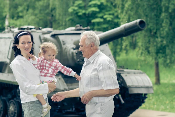 Family on the background of military equipment