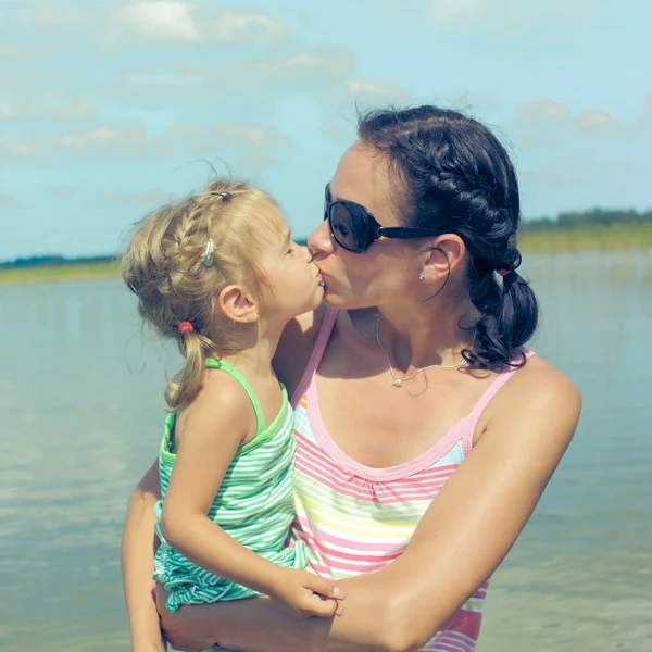 Mom and little  daughter kissing