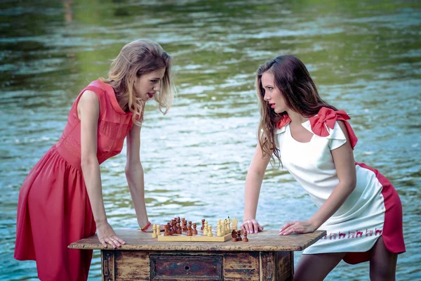 Girls in a dress playing chess