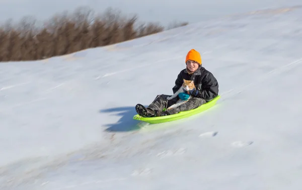 Boy with cat slips into the sledding run