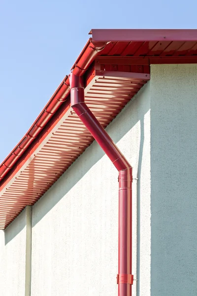 Red roof gutter on house facade