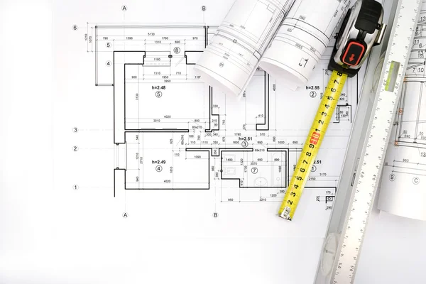 Architectural project, blueprint rolls and tape measure with spi