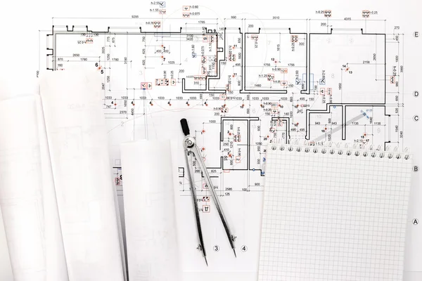 Architectural blueprint rolls with drawing compass and notepad