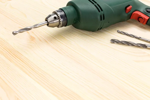 Electric drill on wooden floor background