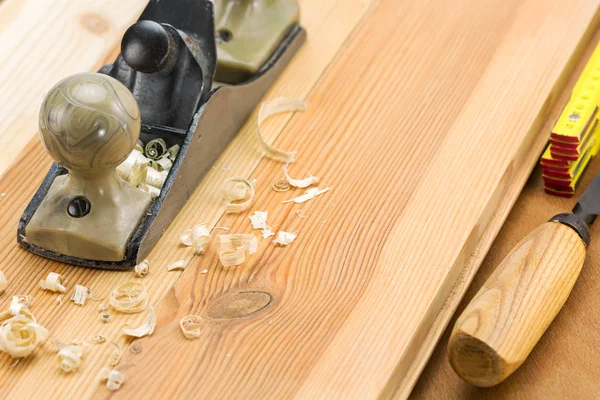 Plane on wooden table with shavings