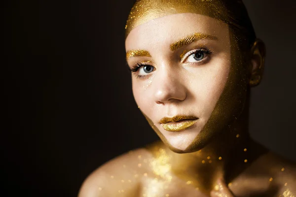 Woman with gold face make up
