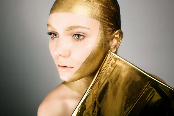 Woman with gold face make up