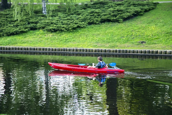 Single kayaker swims on a city channel in Riga