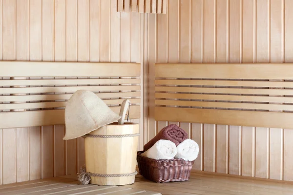 Traditional wooden sauna for relaxation with bucket of water and