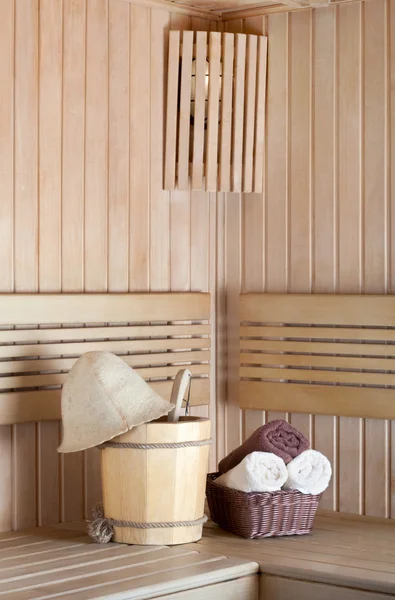 Traditional wooden sauna for relaxation with bucket of water and