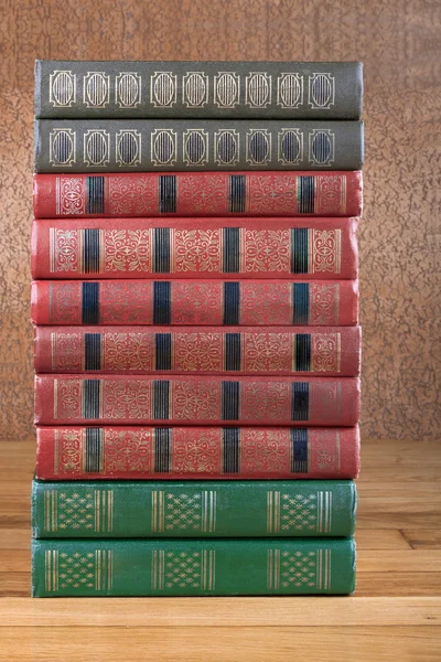 Richly decorated volumes of books with a gold lettering on the b