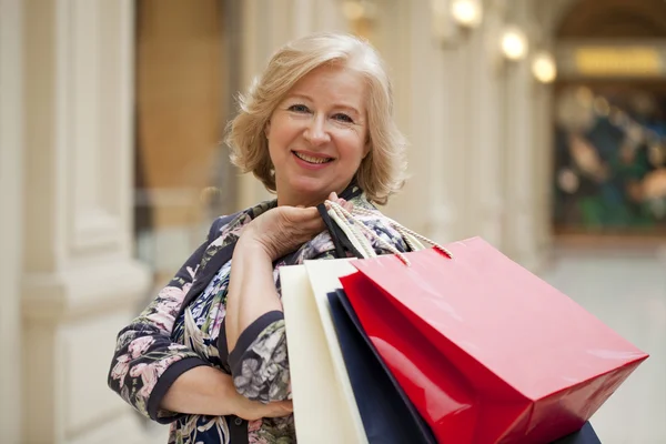 Mature happy woman with shopping bags