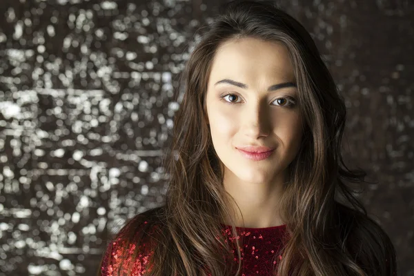 Young brunette woman on dark studio wall background