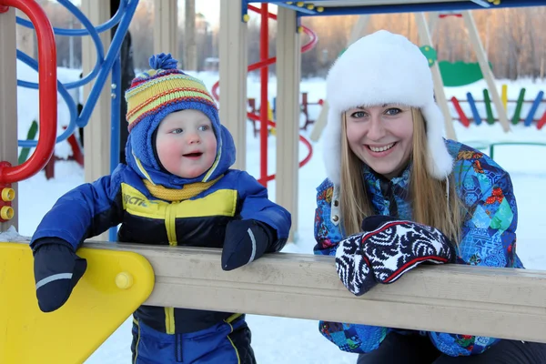 Young mother and son walking in winter park