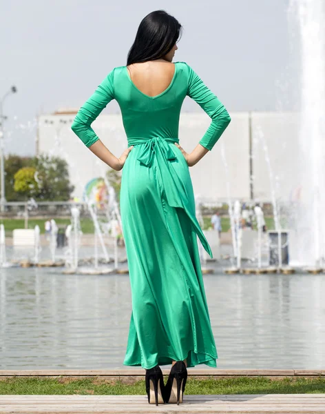 Beautiful young woman in green long dress