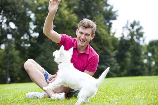 Young man playing with his dog in the park