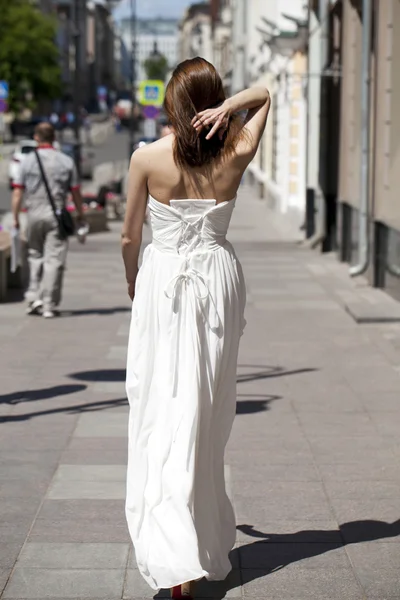 Full length portrait of beautiful model woman walking in white d