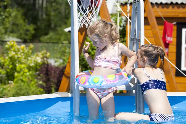 Two sisters in bikini near swimming pool. Hot Summer