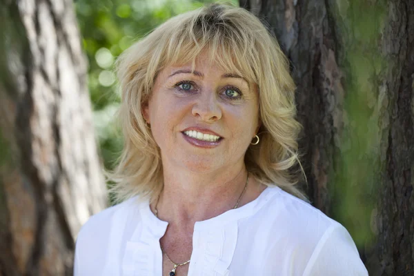 Portrait of lovely middle aged woman in the summer park