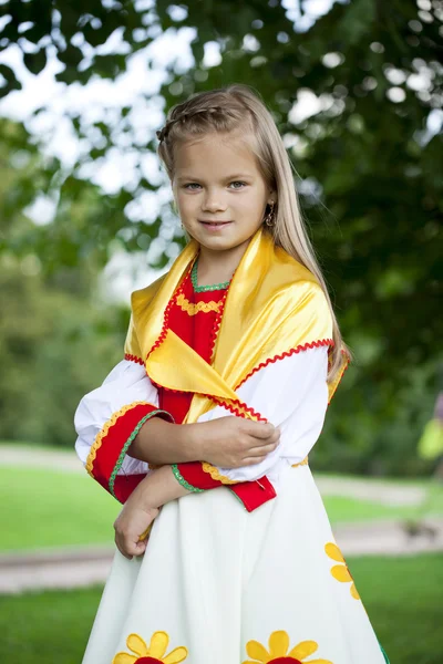Little girl is dressed in the Russian national dress in summer p