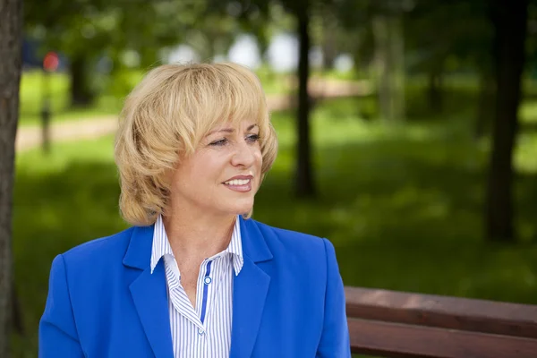 Portrait of an elderly beautiful woman in blue jacket