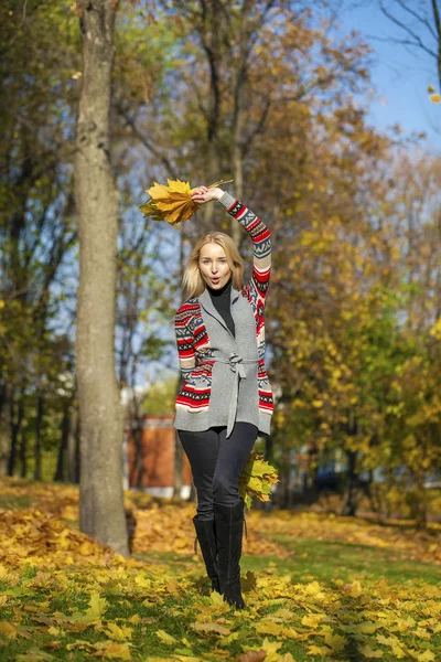 Happy Beautiful blonde woman walks in autumn park