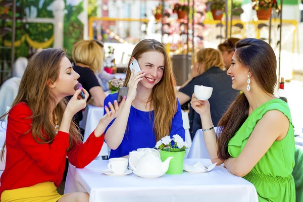 Three happy beautiful girls girlfriend drinking tea in a summer