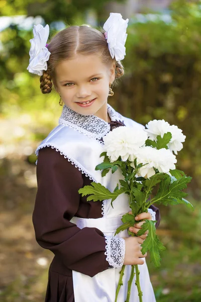 Portrait of a beautiful young first-grader in a festive school u