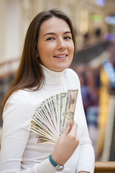 A young woman with dollars in her hands