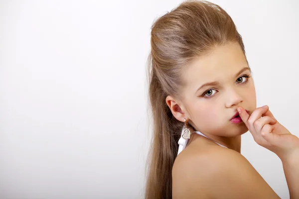 Little girl has put forefinger to lips as sign of silence