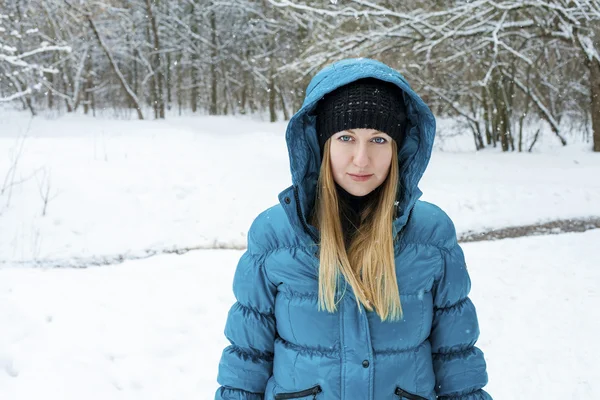 Winter woman in rest snow park. Girl in a turquoise feather bed