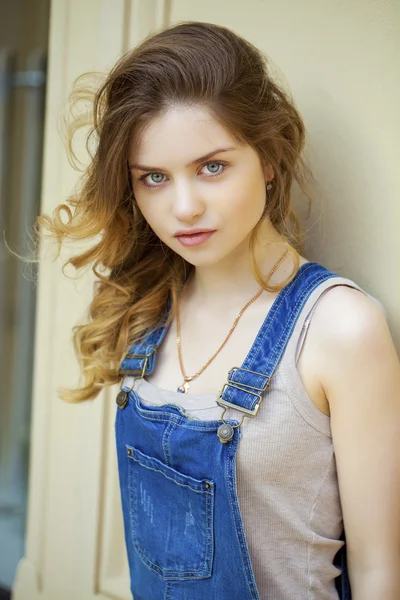 Portrait of a young girl in denim overalls