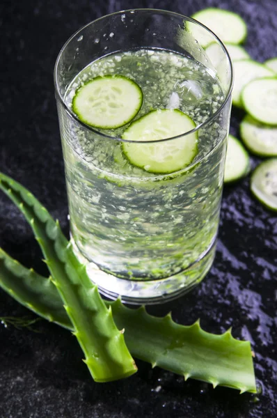 Glass of water with cucumber slices and aloe