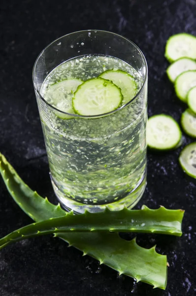 Glass of water with cucumber slices and aloe