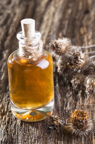 Bottle with burdock oil and dry flowers