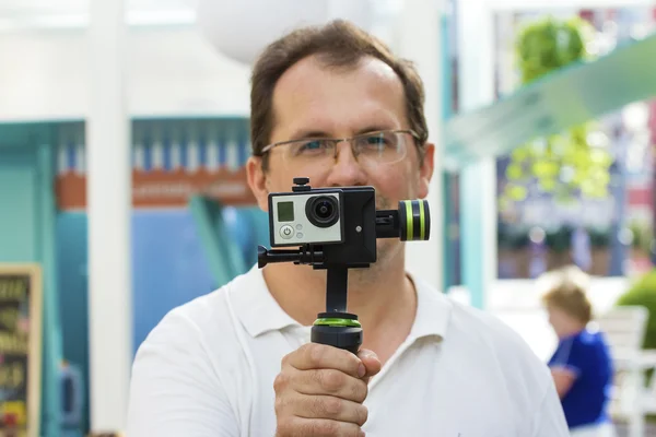 Man holds small action camera