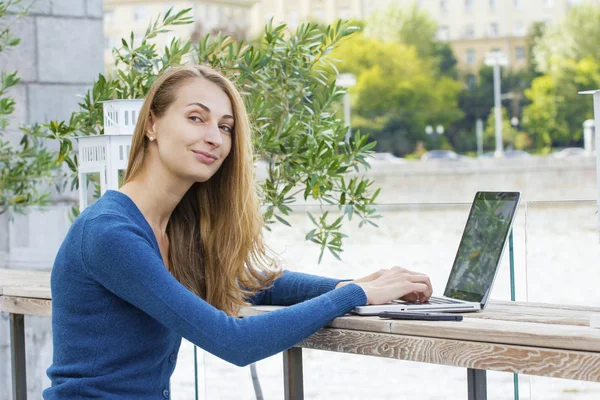 Woman with laptop outdoors.