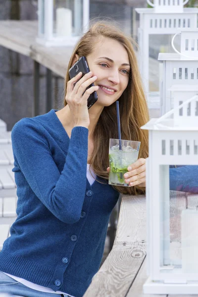 Beautiful Woman with cocktail in cafe mobile phone speaking.