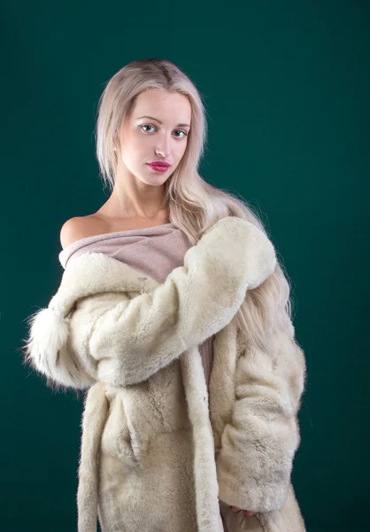 Young Woman Fashion Model dressed in white fur coat