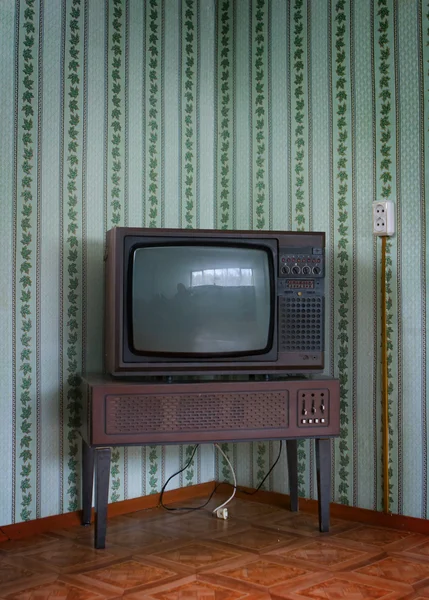 Retro tv with wooden case in room with vintage wallpaper