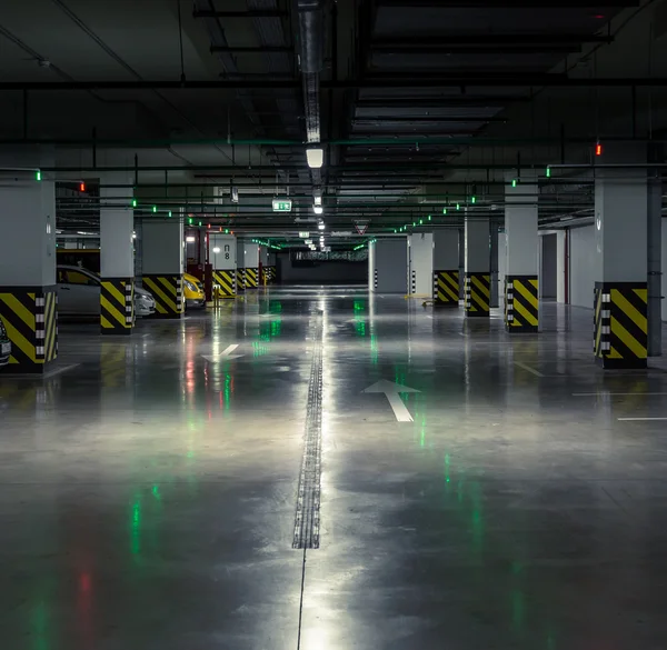 Parking garage, underground interior with a few parked cars