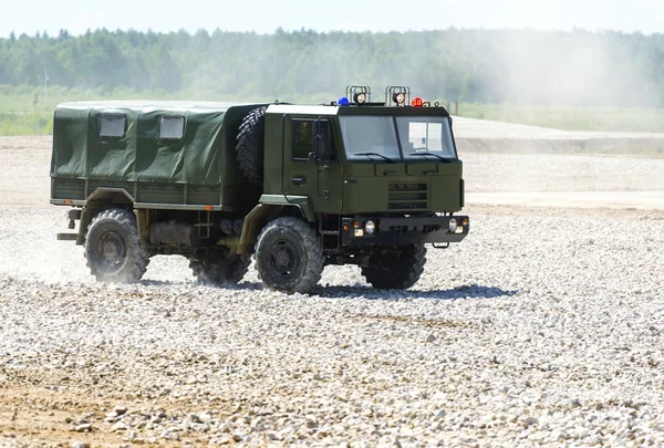 Military vehicle goes on the dusty road