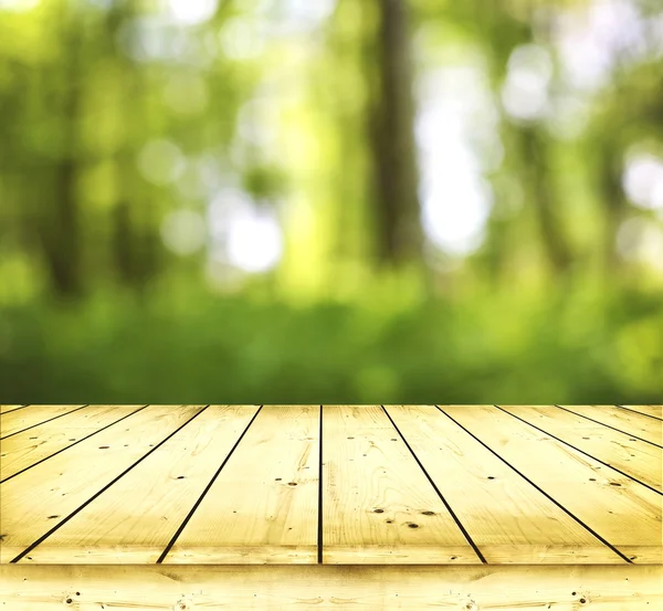 Wooden table on green background