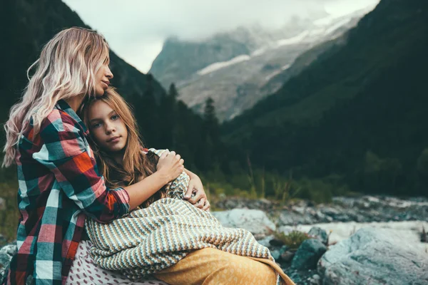 Mom with daughter wrapped in blanket
