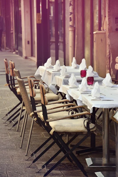 Romantic cafe terrace with empty tables and chairs on street in