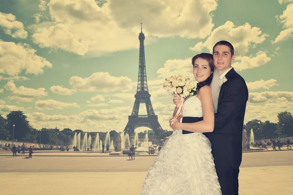 Beautiful wedding couple. Bride and groom in front of the Eiffel Tower in Paris. Retro Style