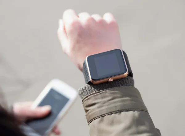 Close up of female hands with smart watch and phone