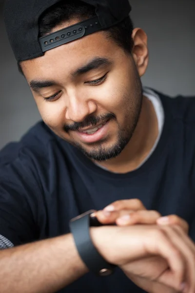 Young black rapper guy using smart wrist watch