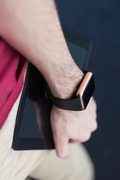 Man holding a tablet pc in a hand with smart watch